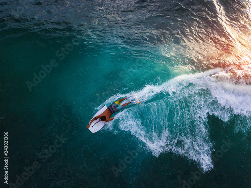 Bodyboard surfer rides tropical wave at sunset