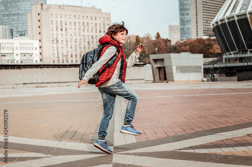 Boy skipping home after receiving a good mark at school