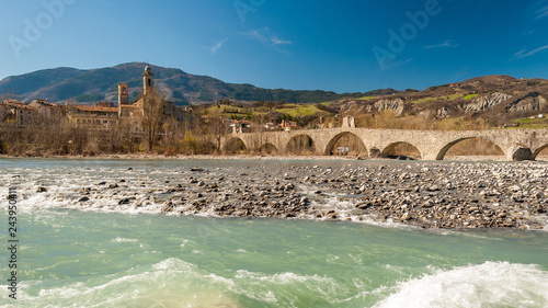 View of the old medieval bridge, called "Ponte del Diavolo" or "Ponte Gobbo" over the river Trebbia in the small town of Bobbio (northern Italy)