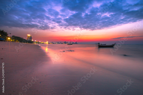 The background of the sea and the evening twilight by the beach, is a natural beauty each day, with fishing boats docked and there is a blur of ocean waves