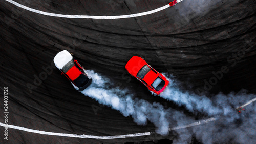 Car drift battle on abstract black texture and background tire skid mark, Two car drifting battle on race track with smoke, Aerial view automobile and automotive.