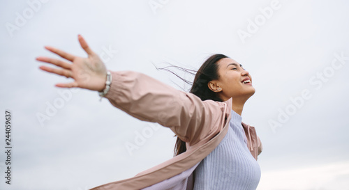 Asian woman enjoying nature standing with open arms