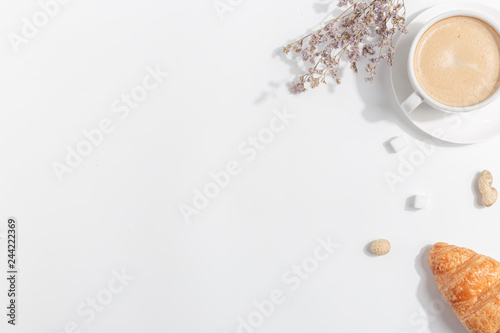 A cup of coffee with milk on a light background. Top view. Copy space.