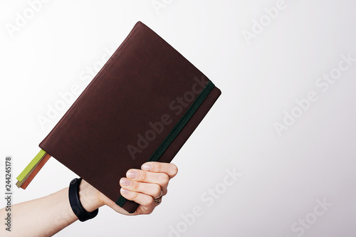 A simple brown book or agenda in handsome hand, over white background