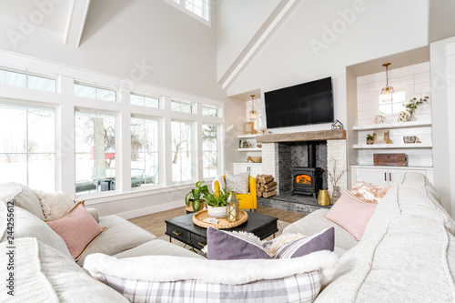 A modern farmhouse family room with transom windows and a wood burning stove.