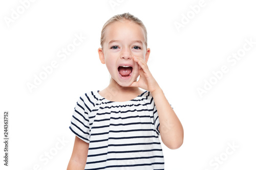 Cute little girl in stripped T-shirt shouting. Speech therapy concept over white background.