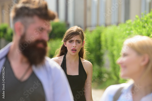 Very jealous and insecure. Unhappy girl feeling jealous. Jealous woman look at couple in love on street. Romantic couple of man and woman dating. Bearded man cheating his woman with another girl