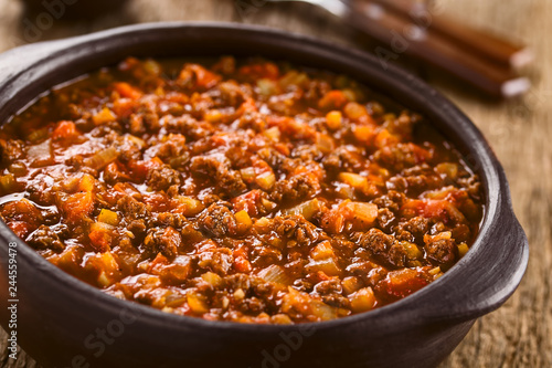 Homemade vegan bolognese sauce made with soy meat, fresh tomatoes, onion and garlic, served in rustic bowl (Selective Focus, Focus one third into the sauce)