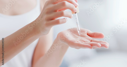woman dropping moisturizer in hand