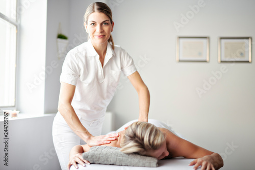 A Woman enjoying spa treatment at salon with masseur worker