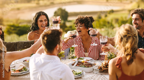 Group of cheerful friends having wine at party