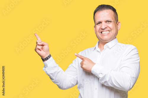 Middle age arab elegant man over isolated background smiling and looking at the camera pointing with two hands and fingers to the side.