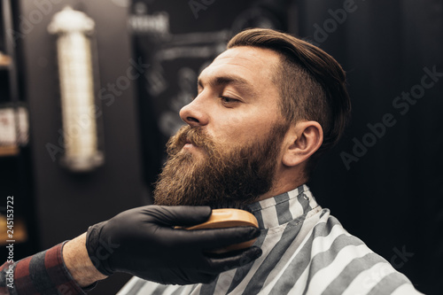 Modnisia młody przystojny mężczyzna odwiedza fryzjera męskiego sklep. Modna i stylowa broda oraz krój.