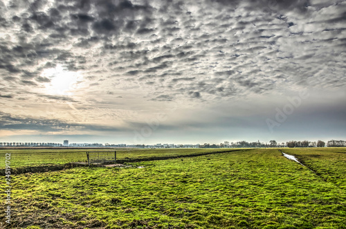 A dramatic sky over meadows and ditches in the open polder landscape of Midden Delfland, south of Delft, The Netherlands