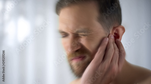 Man feels pain in middle ear, meningitis and hearing loss, inflammation, closeup