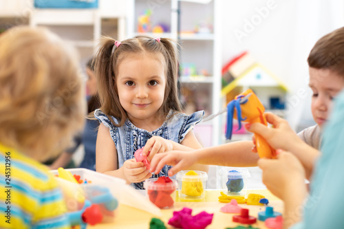 Group of kids playing with modeling clay in nursery