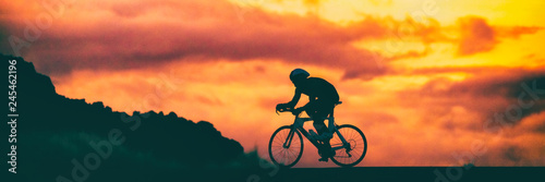 Drogowego roweru triathlon biegowy cyklista na ścigać się roweru jechać na rowerze rywalizację przy zmierzchu tła nieba sztandaru panoramą.