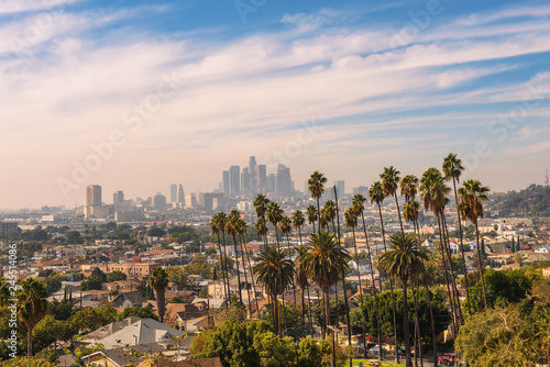 Los Angeles skyline at sunset with palm trees in the foreground