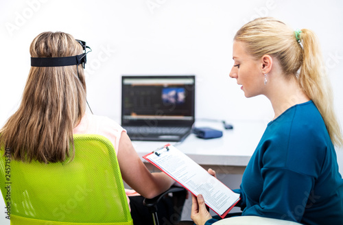 Young teenage girl and child therapist during EEG neurofeedback session. Electroencephalography concept.