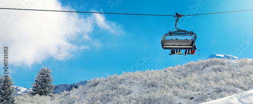 winter vacation - chair lift above snowy mountain landscape at ski resort
