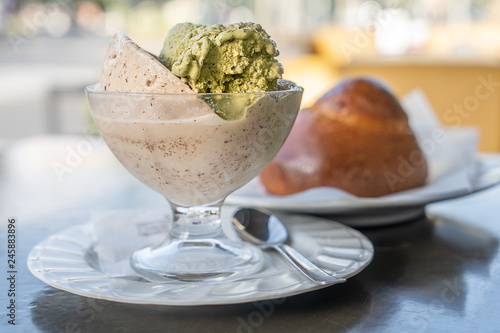 Granita siciliana al gusto di mandorla tostate e pistacchio con brioche sullo sfondo