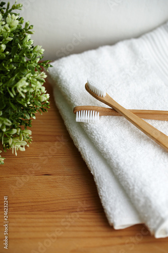 Two bamboo toothbrushes on white towel
