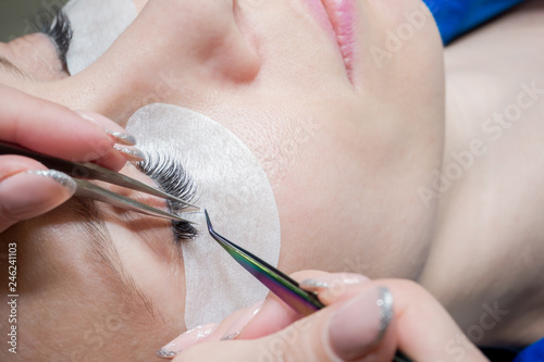 Process of eyelash extension in a beauty salon. Close up.