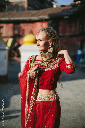 European woman wearing dreadlocks and Indian red dress