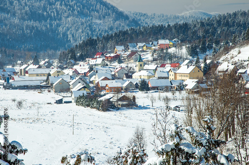  Croatian countryside landscape in winter, panorama of town of Lokve under snow in Gorski kotar, mountains in background 