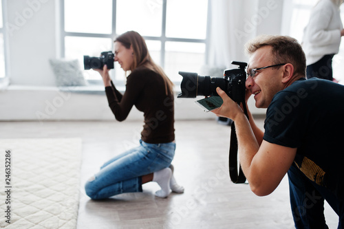 The team of two photographers shooting on studio. Professional photographer on work.