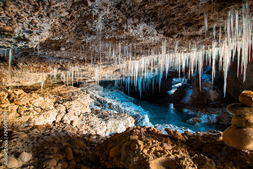 Many icicles hanging from the ceiling of the cave.