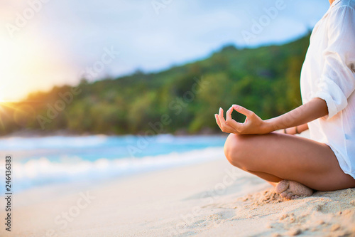 Closeup of Woman's Practicing Lotus Pose on the Beach at Sunset