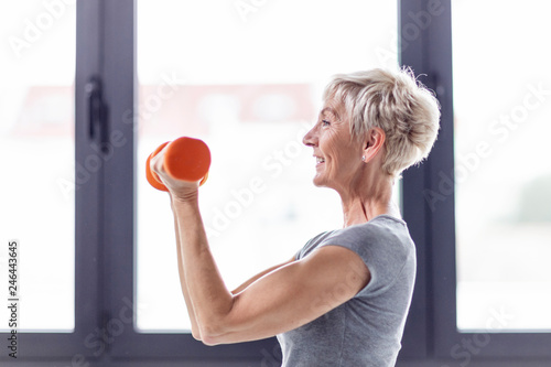 Mature woman exercise with weight on hands