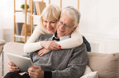 Senior couple using digital tablet, having video call
