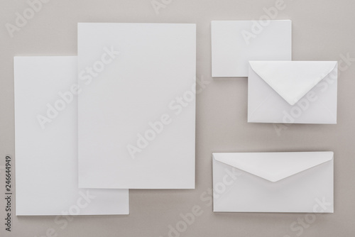 flat lay with white blank papers and envelopes on grey background