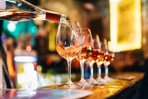 Service Serving Pouring Wine in shiny glasses in bar restaurant night club