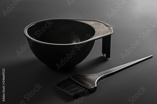 Hair coloring tools: black brush and bowl on a black background