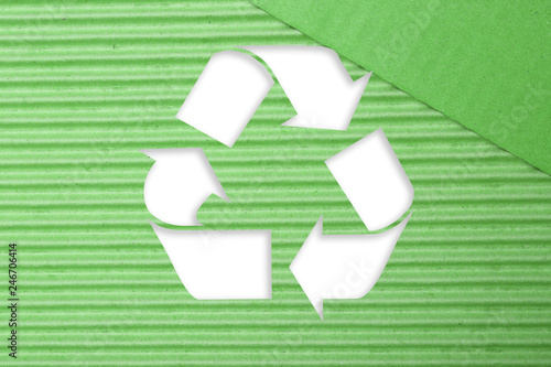 Symbol of recycling on green corrugated cardboard background