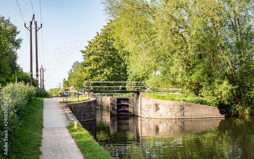 English canal lock and tow path, Hertfordshire, England. A spring rural canal scene on the River Lee Navigation, near Cheshunt, north of London.