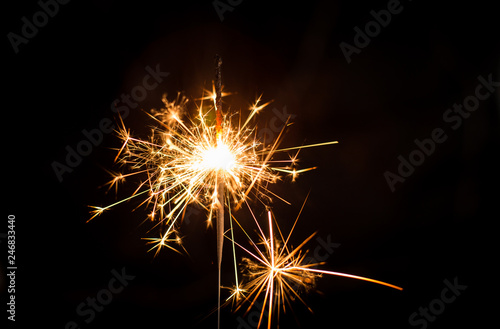 Christmas sparkler or firework on light bokeh background
