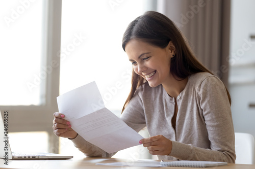 Happy excited woman student customer reading letter with good news, great cheap offer, get job opportunity, scholarship admission, loan approval, money refund holding paper mail bank statement