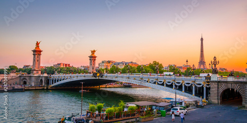 Sunset view of Eiffel Tower and Alexander III Bridge in Paris, France.
