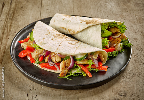 Tortilla wraps with fried chicken meat and vegetables