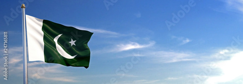 Flag of Pakistan rise waving to the wind with sky in the background