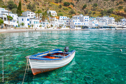 Fishing boat and the scenic greek village of Loutro in Crete, Greece