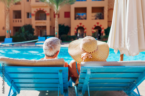 Senior couple relaxing by swimming pool. People enjoying vacation. Valentine's day