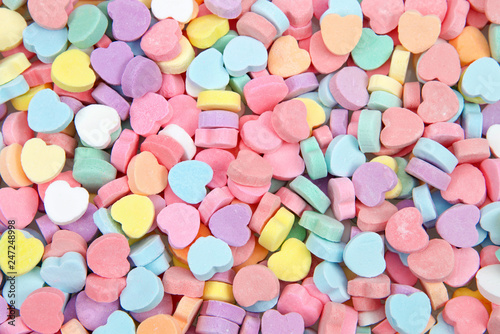 Background of brightly colored candy hearts for Valentine's Day.