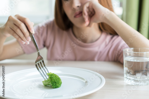 Woman on dieting. Depressed teen looking at her empty plate dinner.