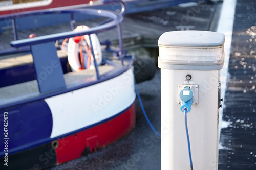 Electric charging point for boat and barge at marina mooring on canal