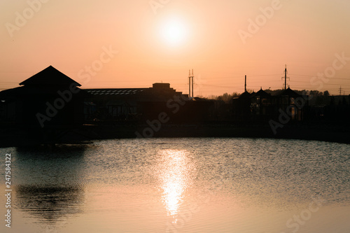 Sunset on the background of the reservoir and buildings.
